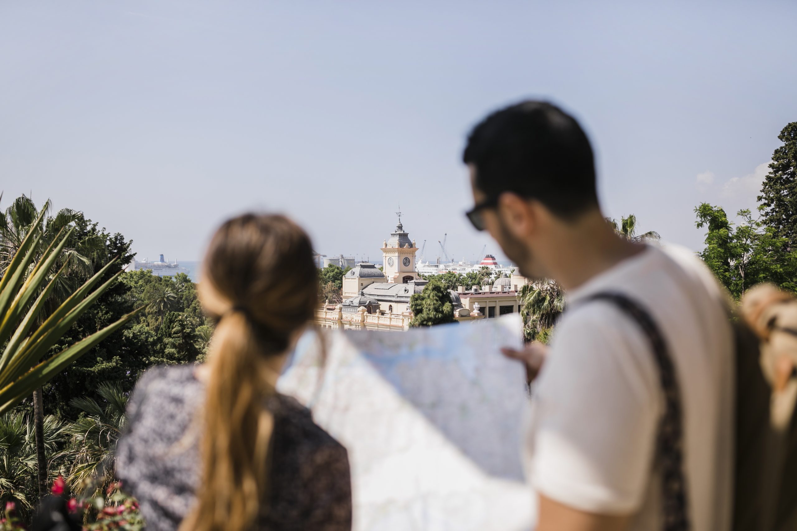 vista-trasera-del-turista-mirando-el-mapa-explorando-la-ciudad